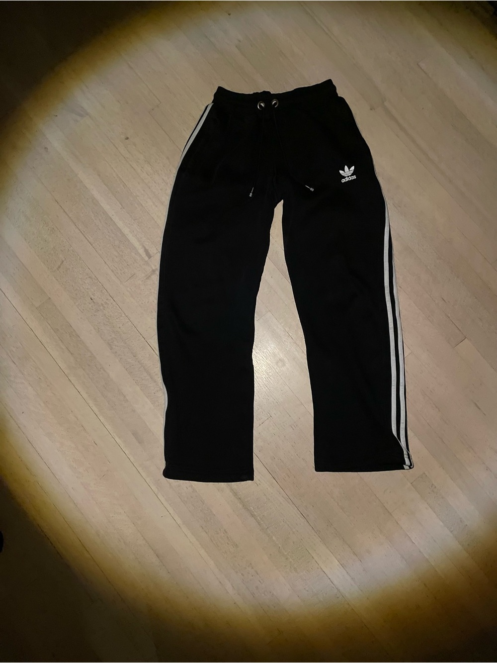 Woman’s black adidas baggy sweats with white striped accents
